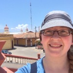 woman stands in front of red domed church